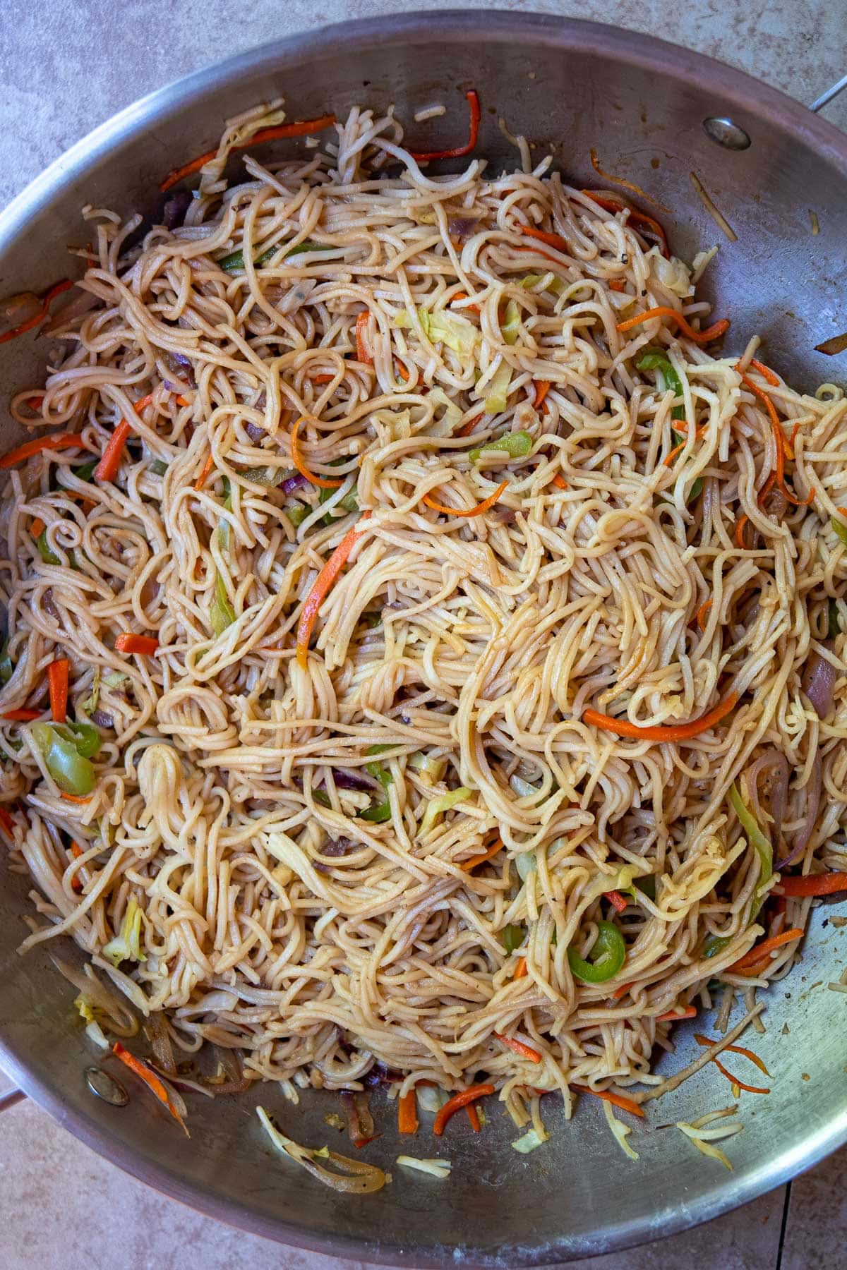 vegetable chow mein being amde in a steel wok