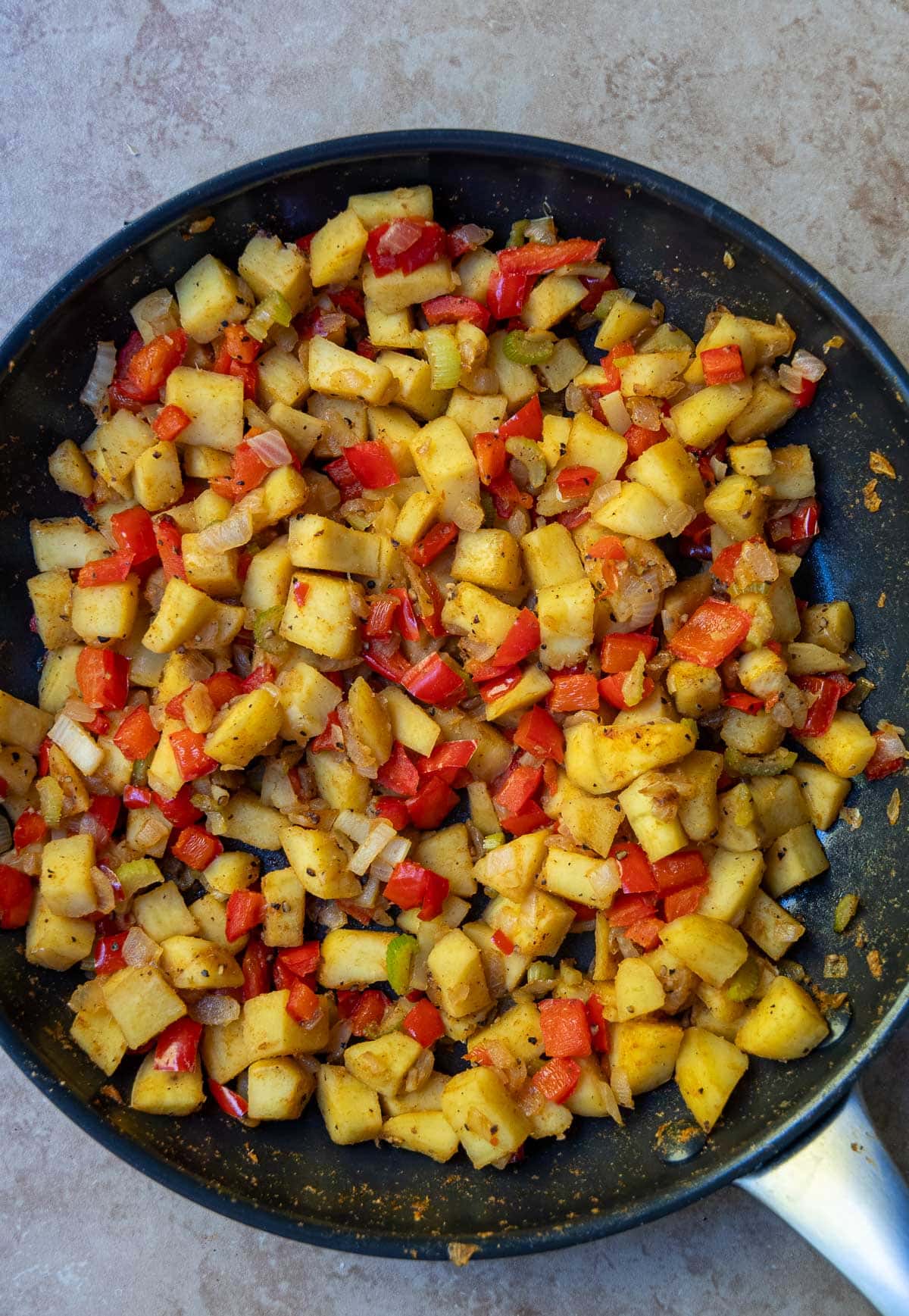 The finished sweet potato hash in a black non stick pan 